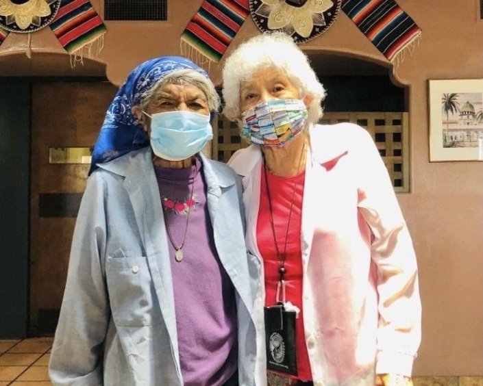 Two native elders standing together with a mask on posing for Protect Native Elders