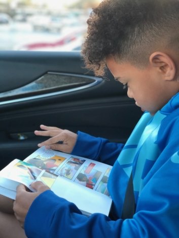 young boy reading the UnCommons comic in the car