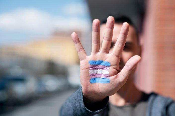 Trans flag painted on hand representing trans people