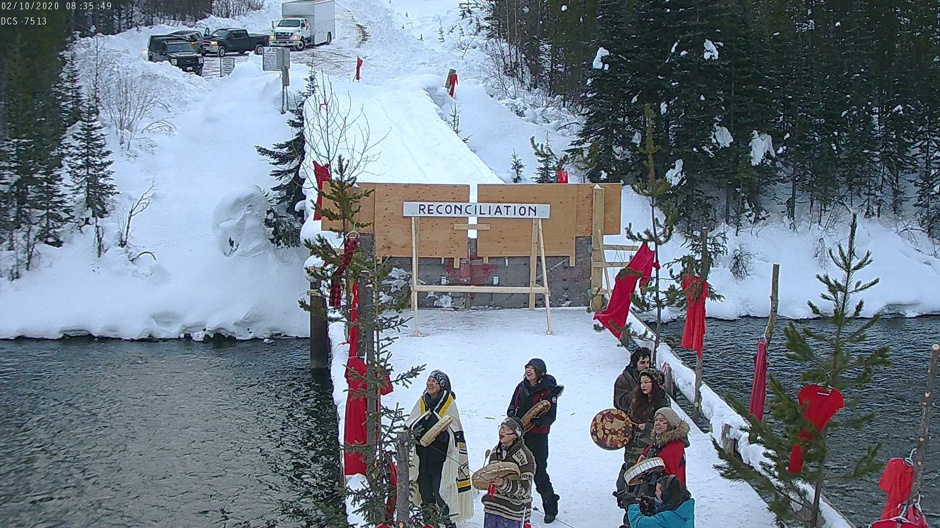 Matriarchs accompanied by one male media and one male indigenous supporter are standing on the snow-covered bridge at Unist’ot’en' Camp checkpoint are calling the ancestors. 