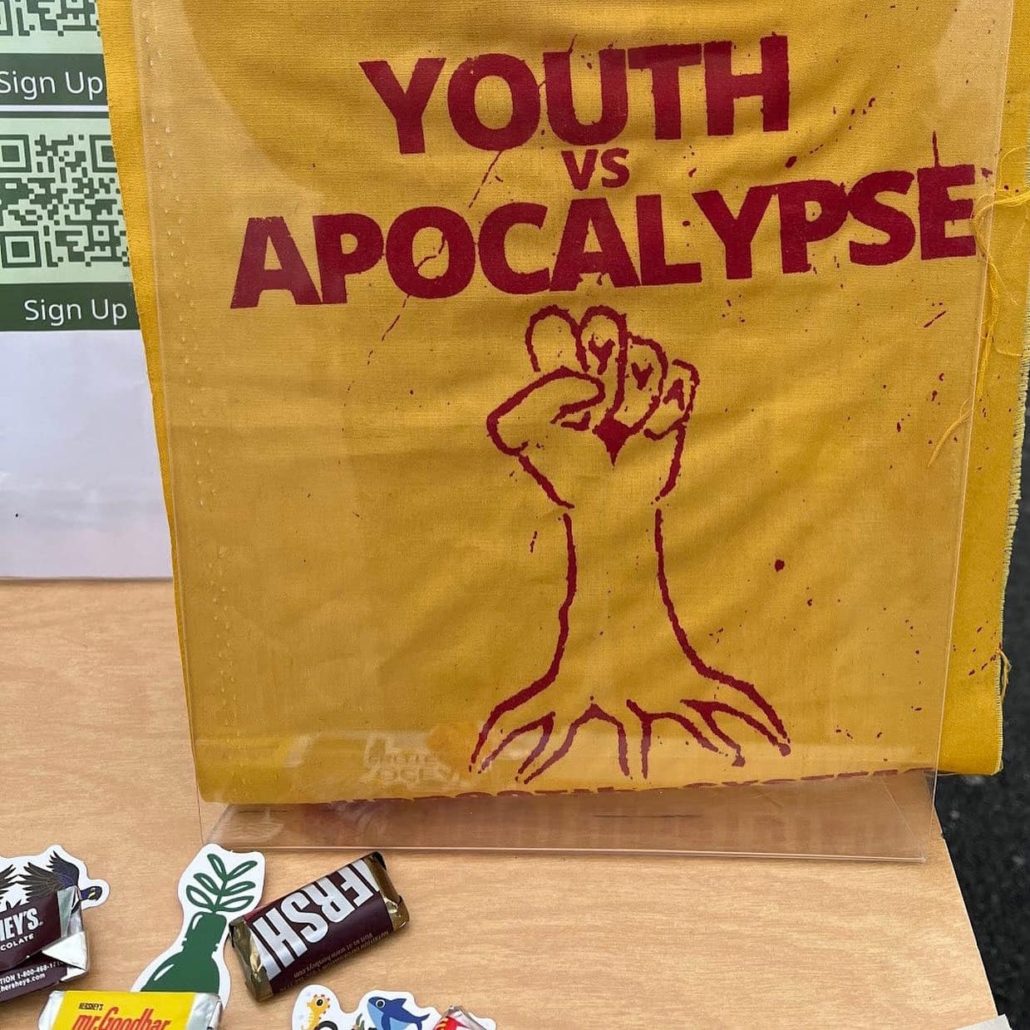 Youth Vs. Apocalypse sign with a fist in the air coming from a root